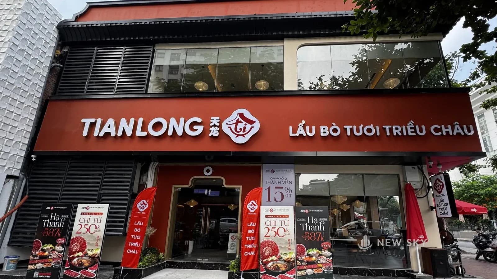 Mặt tiền phía phố Huỳnh Thúc Kháng: dải biển đỏ cam có chữ "TIANLONG", logo và dòng "LẨU BÒ TƯƠI TRIỀU CHÂU"; cửa vào trong khung đỏ có đỉnh uốn 2 bậc; bên trái cửa là mảng lam nan màu tối ở cả 2 tầng.