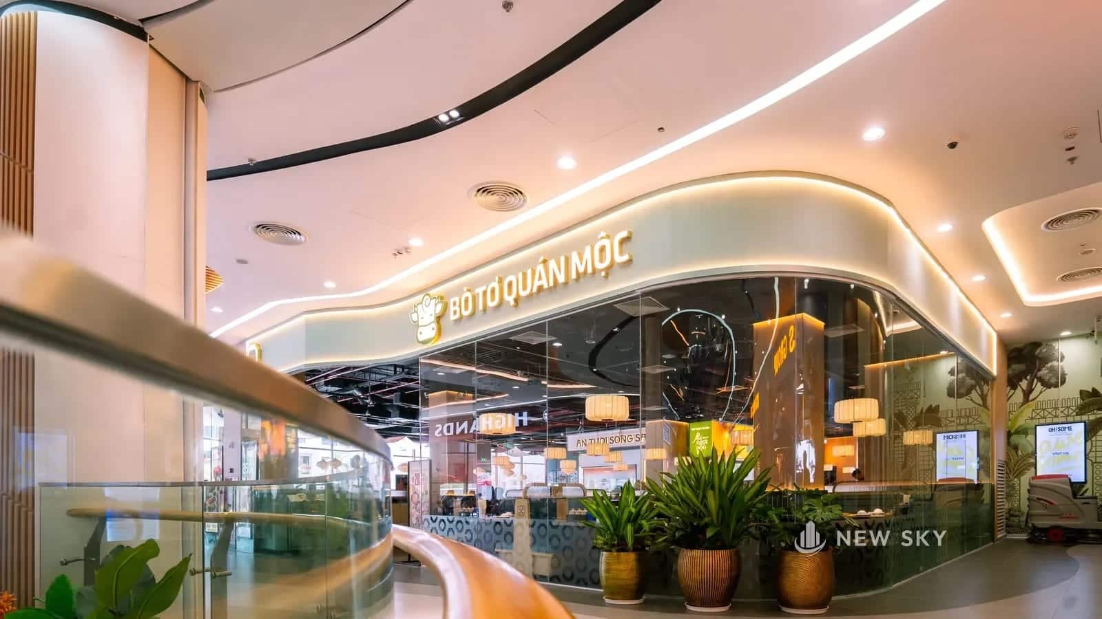 Mặt tiền Bò Tơ Quán Mộc trong Vincom Mega Mall Royal Island, biển chữ nổi có đèn hắt và trần uốn cong.