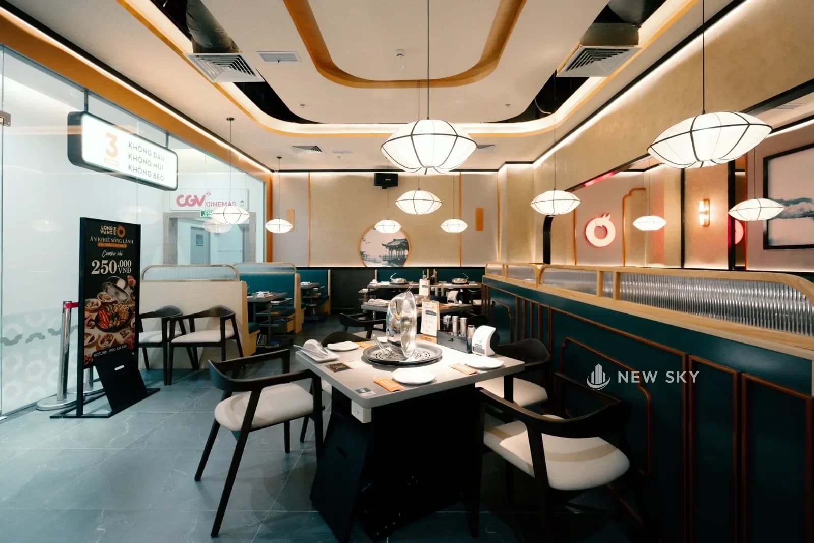 Mặt tiền Long Wang Vincom 191 Bà Triệu nhìn từ hành lang trung tâm thương mại: biển hiệu chữ nổi trên vách ốp, cổng vòm bo tròn và vách kính chạy dài.