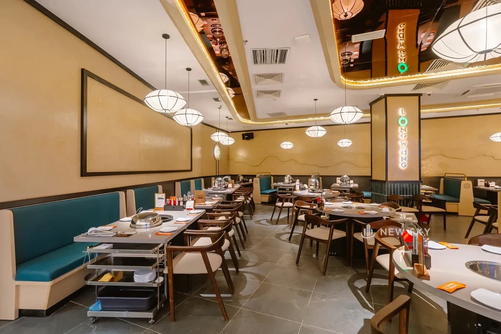 Mặt tiền Long Wang Vincom Plaza 910A Ngô Quyền nhìn từ hành lang trung tâm thương mại: quầy lửng ốp gỗ chạy suốt, biển hiệu chữ nổi trên dầm ngang.