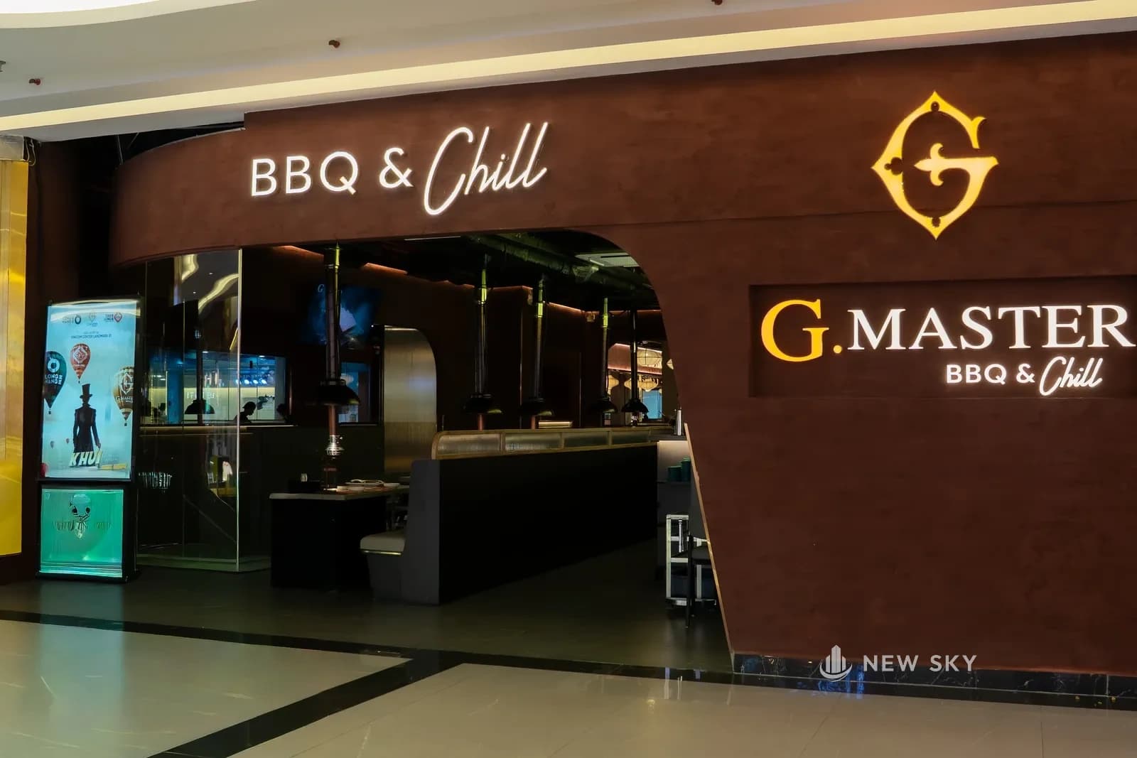 Mặt tiền G.Master tại tầng B1 Landmark 81: mảng tường trát nâu đỏ khoét cổng vòm cong, chữ nổi BBQ & Chill phía trên và biển G.Master gắn bên phải.