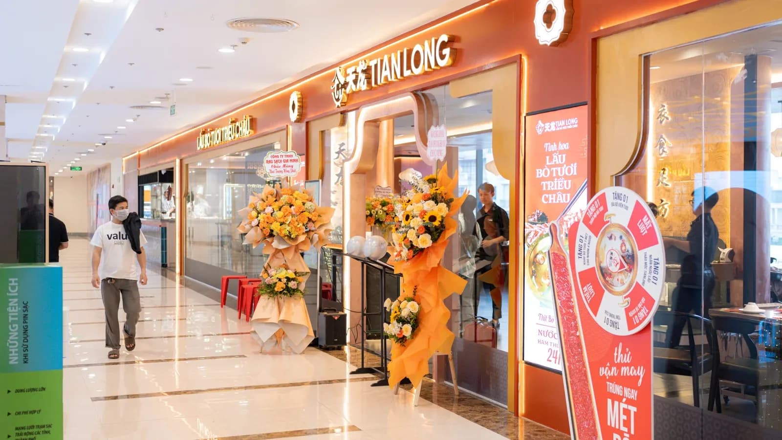 Mặt tiền Tian Long chạy dài dọc hành lang tầng 3 Vincom Imperia, biển chữ nổi và hoa mừng khai trương.