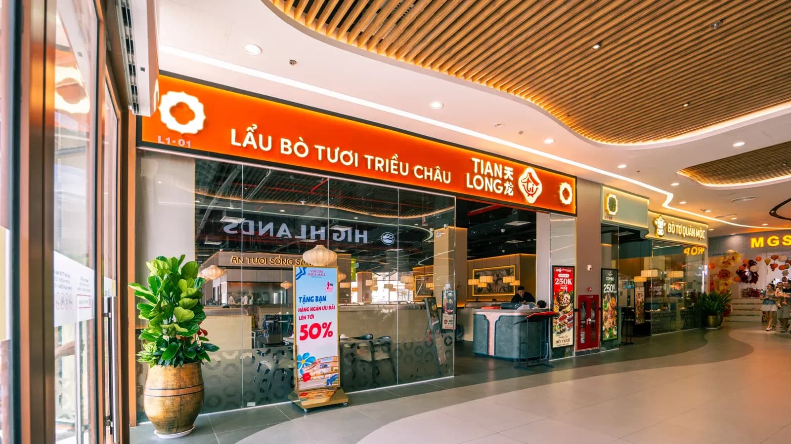 Mặt tiền Tian Long ở tầng một Royal Island, kề bên phải là biển Bò Tơ Quán Mộc — 2 gian liền vách.