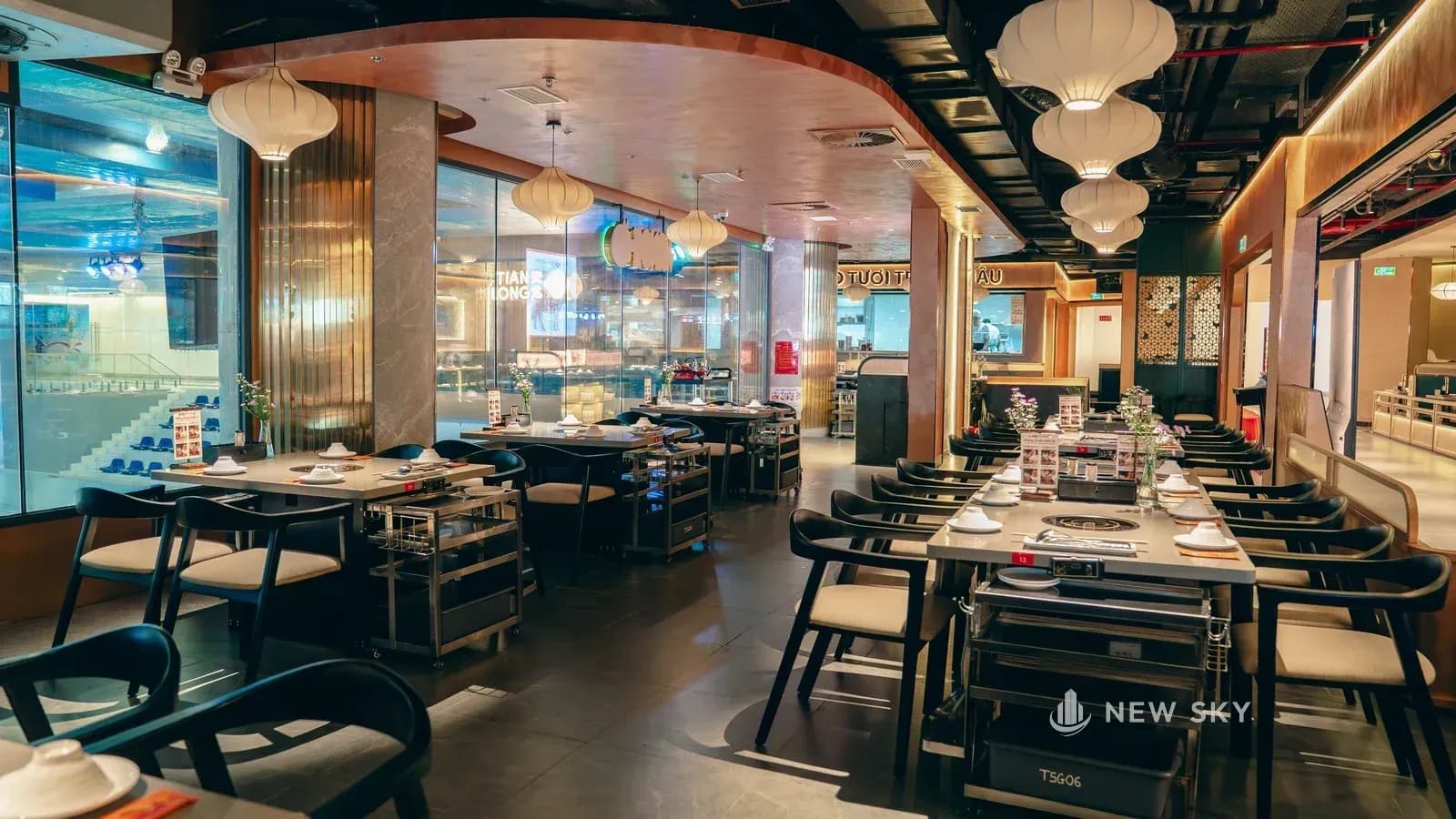 Cạnh dài của gian là mặt kính chạy suốt và hơi uốn cong, bên kia kính là khu sân băng; dọc mặt kính kê dãy khoang ghế băng.